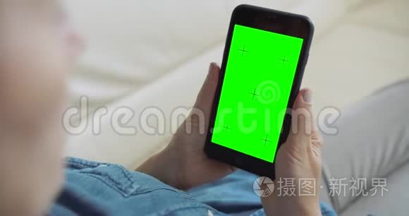 女人拿着绿屏智能手机