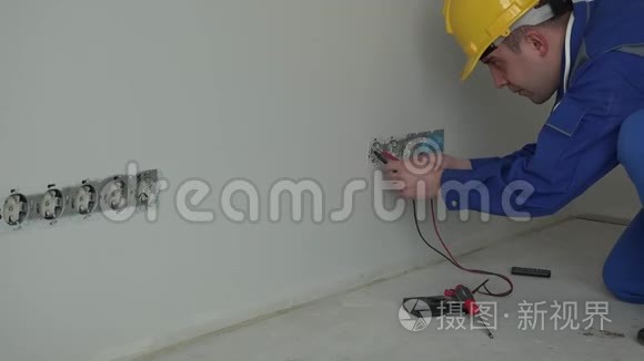 专业男电工使用专用工具检查墙壁插座电压