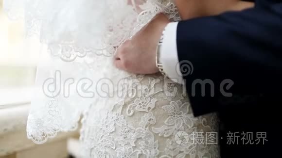 新婚夫妇拥抱，新娘手里拿着一束花