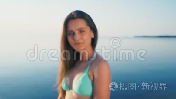 海滩上快乐的年轻女人。 女游客在度假时穿着比基尼，在镜头前做手势表示和平