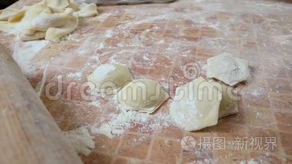在桌子上的面粉中收集高密度的饺子