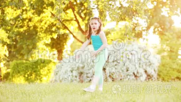 阳光明媚的夏日，可爱的小女孩在公园的树下散步。