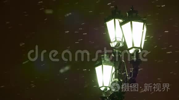 冬天的夜晚。 雪飞过一盏旧式的路灯。 分散注意力。