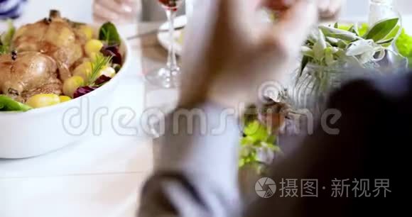 桌子上有鸡肉和土豆的食物细节。 四个快乐的真正坦率的朋友喜欢一起吃午餐或晚餐