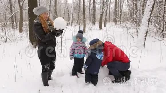 有孩子的小家庭堆雪人。