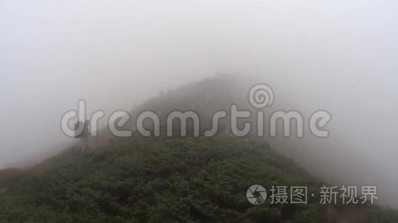 人在暴风雨中在山上徒步旅行视频