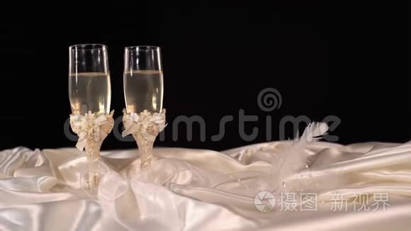 桌上放着闪闪发光的香槟酒的结婚眼镜