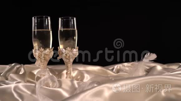 桌上放着闪闪发光的香槟酒的结婚眼镜