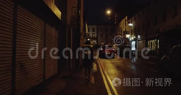 在爱尔兰的一个城市里，一个长着深色头发的少女在街上走得很快。 4k