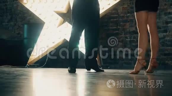 一个男人和一个女人的腿的特写，在房间里跳一对舞厅舞。 探戈的舞步。