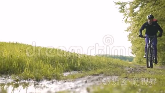 背包客在森林水坑里骑自行车