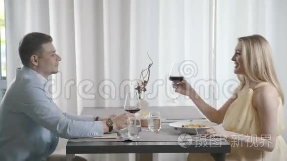 丈夫和妻子在餐馆吃晚饭，女人说祝酒。
