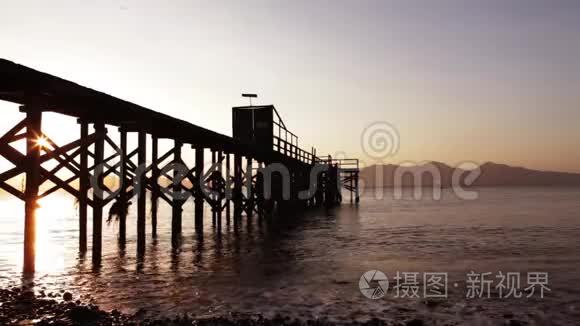 日出时海滩码头剪影