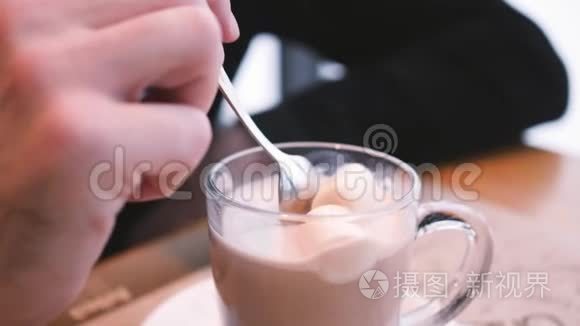 咖啡馆里的热巧克力。 用棉花糖搅拌热巧克力，放入透明的杯子