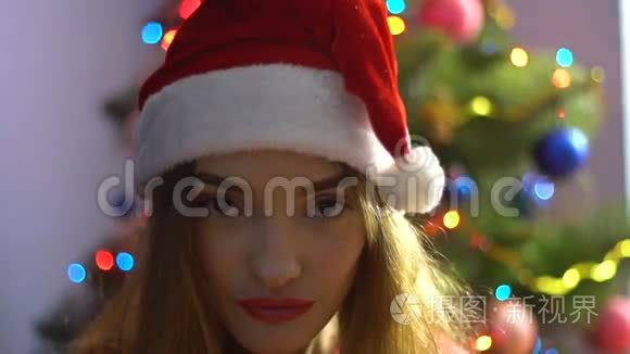 漂亮的红唇少女摘下圣诞帽，对着镜头微笑