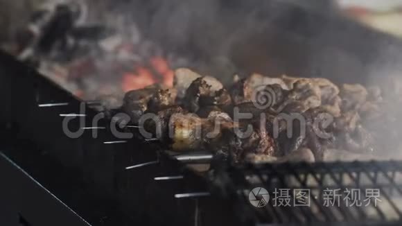 烟从煤串上的油炸肉上升起. 烤架上的肉