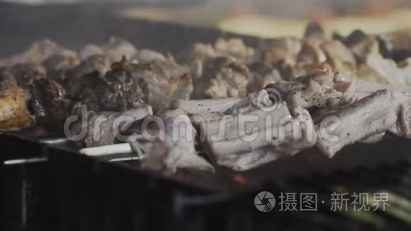 烟从煤串上的油炸肉上升起. 烤架上的肉