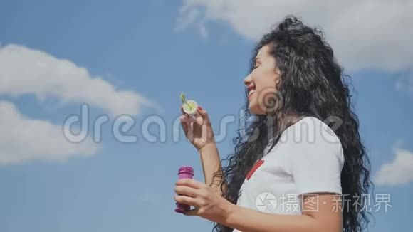 美丽的女孩在天空中吹泡泡视频