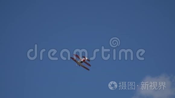 一架美丽的红白飞机在空中表演名为“桶”的特技飞行