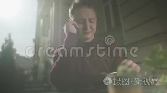 年轻人在咖啡馆的桌子上打电话