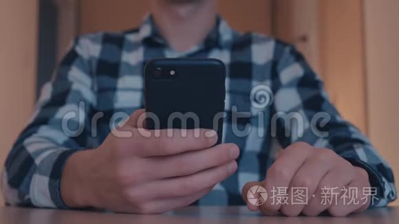 男人手滚动图片，照片在Instagram应用程序使用智能手机在办公室。 关门