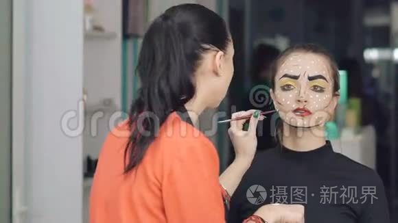 化妆师在工作室里给女孩做万圣节化妆