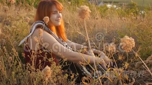 夕阳西下的剪影年轻漂亮的红发女孩在玩萨克斯管自然，一个女人吹进烟斗，概念爱好，音乐