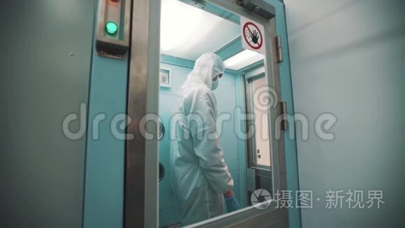 无菌衣服的科学家走出消毒室和实验室
