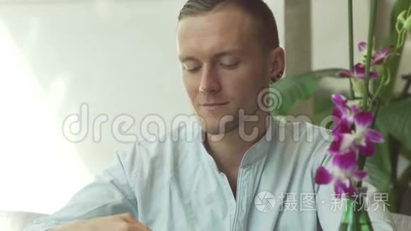 英俊的男人喝着咖啡，微笑着。