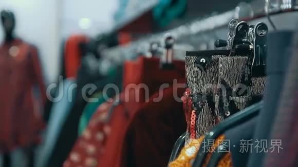 拍摄特写女性`衣服挂在店里的衣架上..