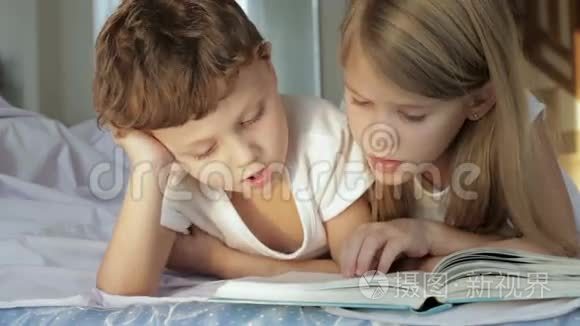 可爱的男孩和他的妹妹在家看书