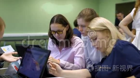 三个十几岁的女孩在教室里做实际的教育工作。