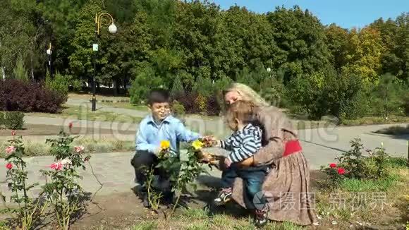妈妈孩子展示了一朵黄色的玫瑰视频