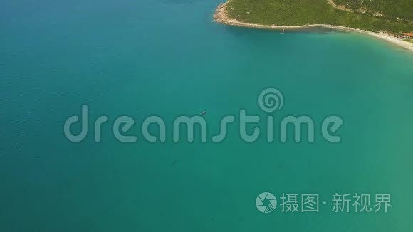 海船在蓝水中航行，靠近沙滩鸟瞰。 从上面可以看到绿松石的海洋和美丽的海岸景色