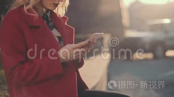 穿着红大褂的女商人坐在商务中心附近，用手机（phablet）。稳定的凸轮射击。