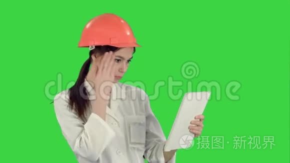 哈达的女建筑专家在绿色屏幕上通过平板电脑进行视频通话，Chroma键