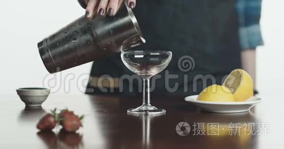 调酒师将鸡尾酒倒入玻璃杯的特写镜头