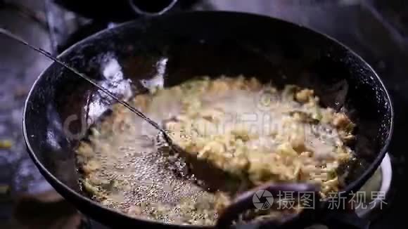 在印度街头美食烹饪。 在印度南部的一个市场上，新鲜的食物是在平底锅里油炸的。