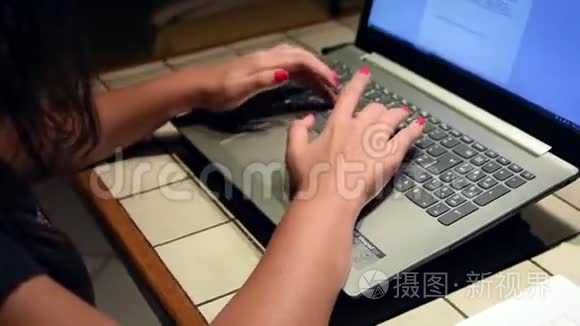 年轻女子的手在她的笔记本电脑里打字