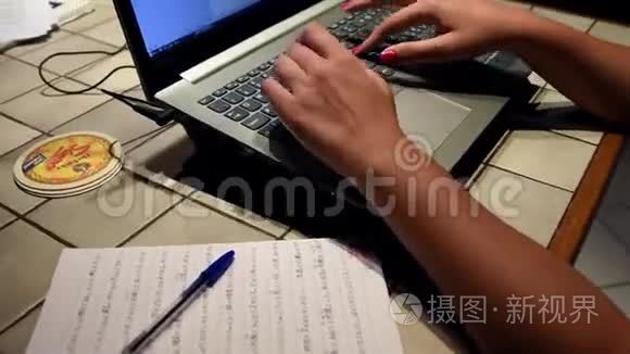 年轻女子的手在她的笔记本电脑里打字