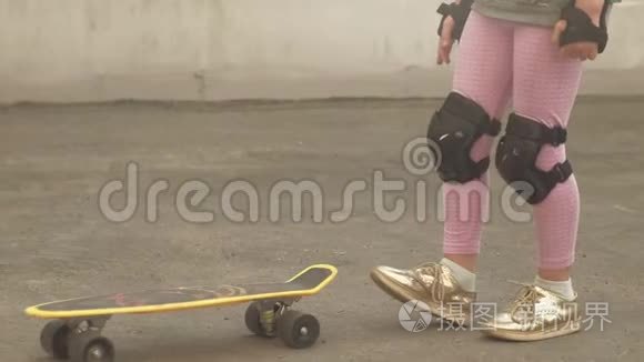 一个小女孩骑在黄色滑板上