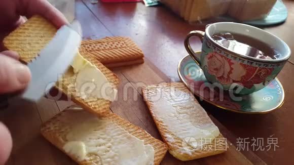 用刀子把黄油撒在麦饼干上吃早餐