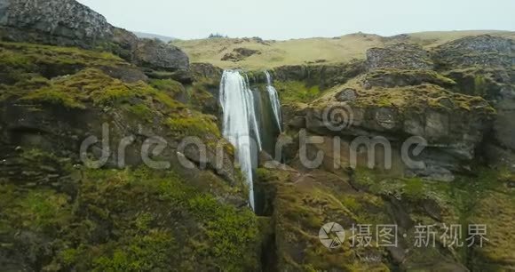 冰岛山上瀑布的鸟瞰图。 直升机在湍流附近飞落下来。