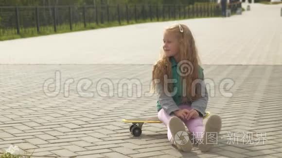 一个小女孩骑在黄色滑板上