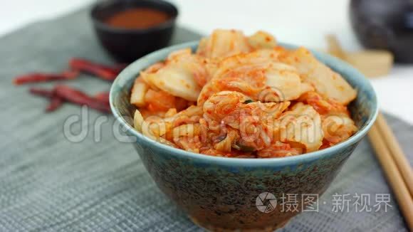 女人用筷子从陶瓷碗里取出传统的韩国卷心菜开胃泡菜