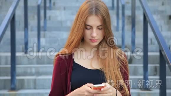 日出时，美丽优雅的长发美女在城市的智能手机上发短信。