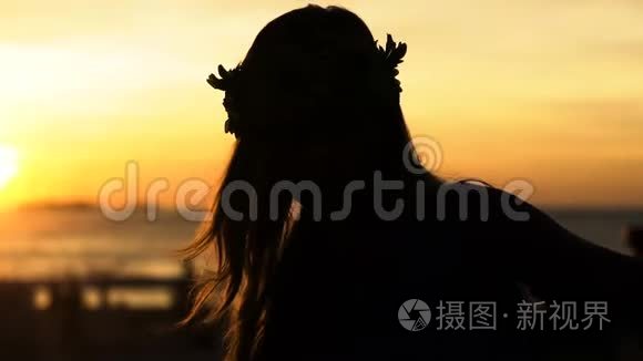 夕阳西下，快乐的女人在海滩上跳舞，背景是大海