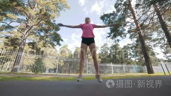 年轻的健身女子跑步前热身运动视频