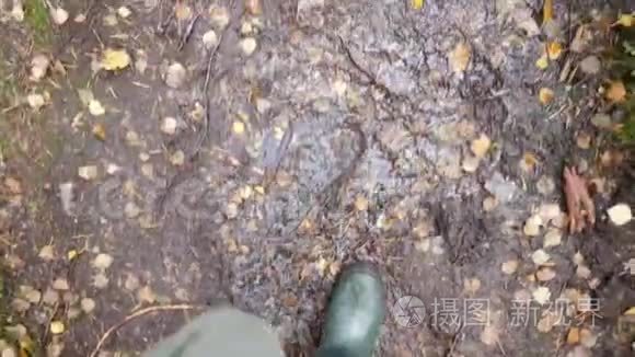 秋雨日橡胶雨靴猎手走林径. 4K，慢动作。 卡雷利亚，俄罗斯。