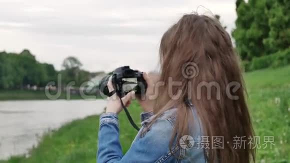 风雨交加，美女游客在河边用专业相机拍摄视频
